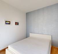 Hálószoba világos falakkal, ággyal és művészettel a falakon, 4 szobás lakás.