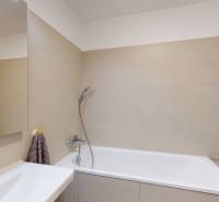 Fürdőszoba káddal és bézs csempékkel egy 4 szobás lakásban.