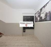 Lépcsőház postaládákkal és világtérképpel, bejárat a kétszobás lakásba.