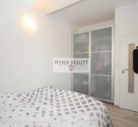 Hálószoba franciaággyal, beépített szekrény, fehér falak a kétszobás lakásban.