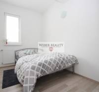 Hálószoba egy kétszobás lakásban, ággyal és fa dekorációjú padlóval.