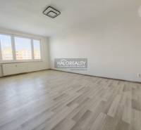 Szoba nagy ablakokkal és fa dekorációjú padlóval egy kétszobás lakásban.