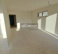 Egy családi ház fehér falakkal és ablakokkal rendelkező belső tere, készen a befejezésre.