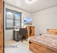 Gyerekszoba egy családi házban, íróasztallal, ággyal és fa dekorációjú padlóval.