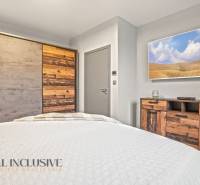 Hálószoba családi házban, bútorokkal és természetes fa dekorral ellátott szekrénnyel.