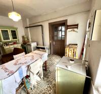 Családi ház étkezője cserépkályhával, asztallal és régi bútorokkal.