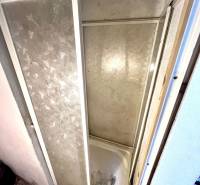 Zuhanykabin családi ház belső terében burkolattal és dekoratív padlóval.