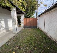 Egy családi ház udvara Jablonecben kőburkolattal és zöld növényzettel.