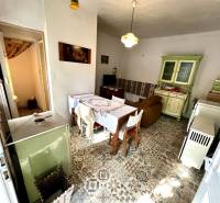 Családi ház belső tere kerámia padlóval, konyhapulttal és étkezőasztallal.