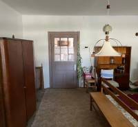 Családi ház belső tere bútorokkal és szőnyeggel, középső lámpa és italpolc.