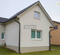 Családi ház Kľačno-ban fehér homlokzattal és ferde tetővel, gondozott gyepen.