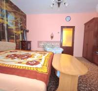 Hálószoba családi házban erdei tapétával és klasszikus fa bútorokkal.