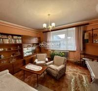 Családi ház nappalija fa dekorációjú bútorokkal és függönyökkel.