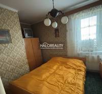 Hálószoba egy háromszobás lakásban retro tapétával és televízióval.