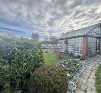 Kertek Iglón üvegházzal, rendezett gyepfelülettel és virágágyással.