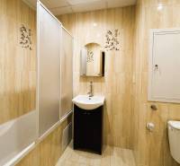 Fürdőszoba káddal, mosdóval és WC-vel egy háromszobás lakásban világos csempékkel.