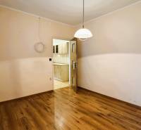 Szoba egy háromszobás lakásban fa dekor padlóval, kilátás a konyhába.