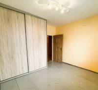 A szoba beépített szekrénnyel és fa dekoros padlóval rendelkezik egy háromszobás lakásban.