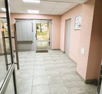 Lakóház előcsarnoka postaládákkal és üvegajtókkal.