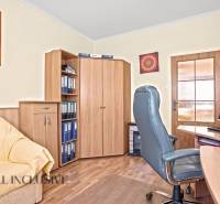 Dolgozószoba egy családi házban irodai székkel és fa mintázatú padlóval.