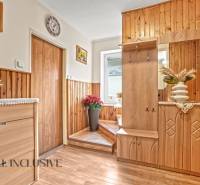 Egy családi ház folyosója fa burkolattal, dekorációkkal és fa mintázatú padlóval.