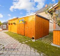 Egy családi ház udvara Dunaszerdahelyen, fa előtetővel és kövezett járdával.