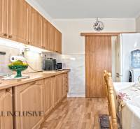 Konyha egy családi házban, fa dekoros padlóval és fa bútorokkal.