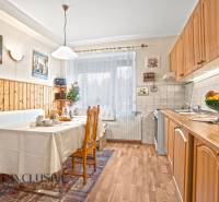 Konyha egy családi házban, fa dekoros padlóval és étkezőasztallal.