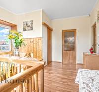 Családi ház belső tere fa dekorációjú padlóval, korláttal és dekorációkkal.