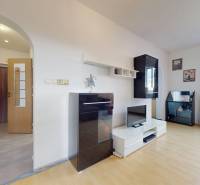 Nappali egy háromszobás lakásban, fa dekoros padlóval, világos bútorokkal.