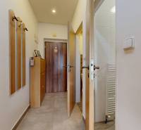 Folyosó fogasokkal és szekrénnyel egy háromszobás lakásban kerámia padlóburkolattal.