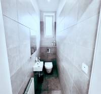 Keskeny WC ablakkal, mosdóval és kerámia csempével. Reality Kováčová irodák.