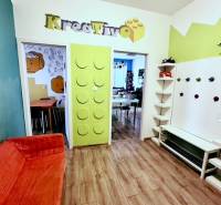 Színes iroda belső tér fa dekor padlóval és kreatív bejárati dizájnnal.