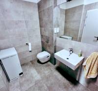 Fürdőszoba WC-vel, mosdóval és mosógéppel az irodákban.