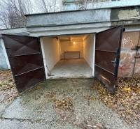 Nyitott garázsok a Priekopy utcában, Pozsony-Ružinovban, őszi levelekkel körülvéve.