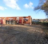 Családi ház építése a Nyitrai Drieňová utcában, félkész téglafalak a természetben.