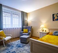 Szoba családi házban ággyal, székkel, asztallal és fa mintázatú padlóval.