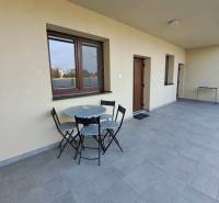 Terasz ülőhellyel egy 4 szobás lakásban, csempézett padlóval és világos falakkal.