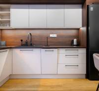 Konyha egy egyszobás lakásban, fa dekorációjú padlóval és modern készülékekkel.