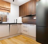 Konyha egy egyszobás lakásban, fa dekorációjú padlóval és modern készülékekkel.