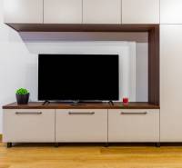 Nappali fal az egyszobás lakásban, fa dekor padló, televízió és dekorációk.