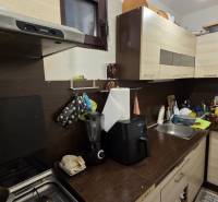 Családi ház konyhája konyhabútorral, mosogatóval és háztartási gépekkel.