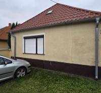 Családi ház a Nagy utcán Nagymácsédon, autóval a gyepen.