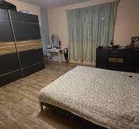 Hálószoba családi házban fa dekor padlóval, gardróbszekrénnyel és ággyal.