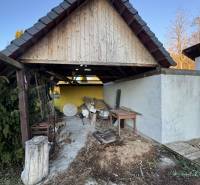 Fedett terasz a családi ház mellett Deménden, régi fa és szerszámok az udvaron.