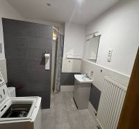 Fürdőszoba családi házban zuhanyzóval, mosógéppel és mosdóval, csempével berendezve.