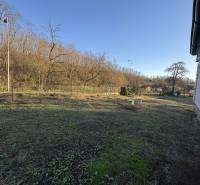 Kert a családi ház mellett Deménden fákkal és kiterjedt füves területtel.