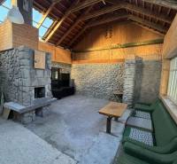 Családi ház belső tere kő kandallóval és fa burkolattal.