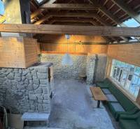 Kőfalak, fa mennyezet és ülőhely egy családi házban.