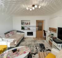 Nappali kényelmes kanapéval egy kétszobás lakásban, fa dekorációjú padlóval.